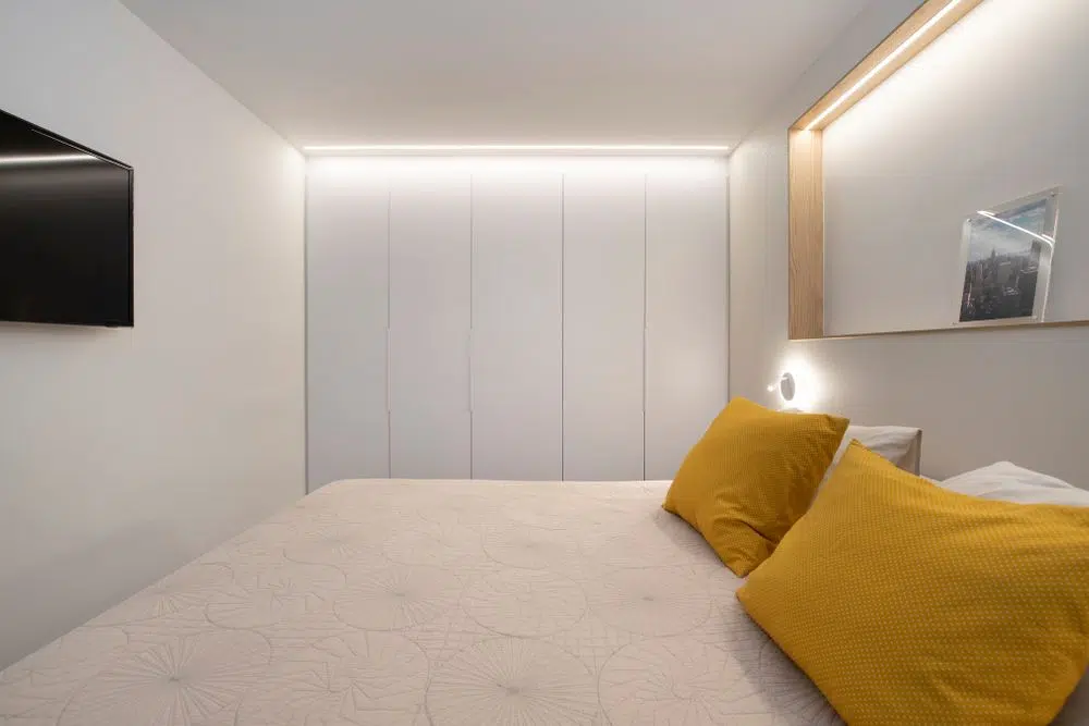 Armari encastat i il·luminació amb tires LED al dormitori principal doble