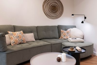 Foto de portada article. Sala d'estar amb aplic de paret al costat del sofà.
