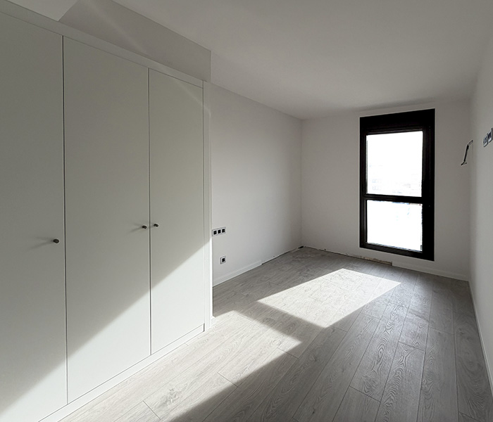 Dormitorio principal sin personalizar en una vivienda de nueva construcción.