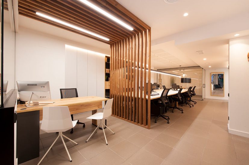 Estructura de listones de madera con tiras Led que hace de divisoria interior oficina.