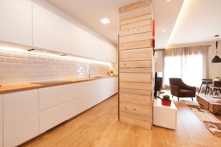 Mueble cocina revestido con madera para separar cocina y salón dentro de un espacio abierto.