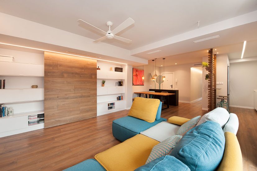 Sala de estar abierta moderna y con toques de color. Sofá y mueble tv.