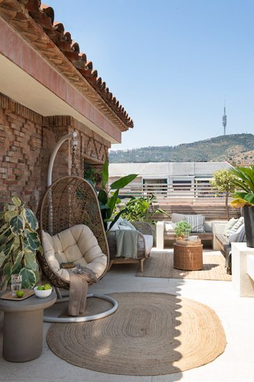 Sillón colgante en la zona para relajarse en la terraza de un ático.