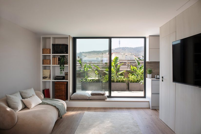 Sala de estar en la zona del terrado con una pequeña cocina y puerta que da acceso al aseo.