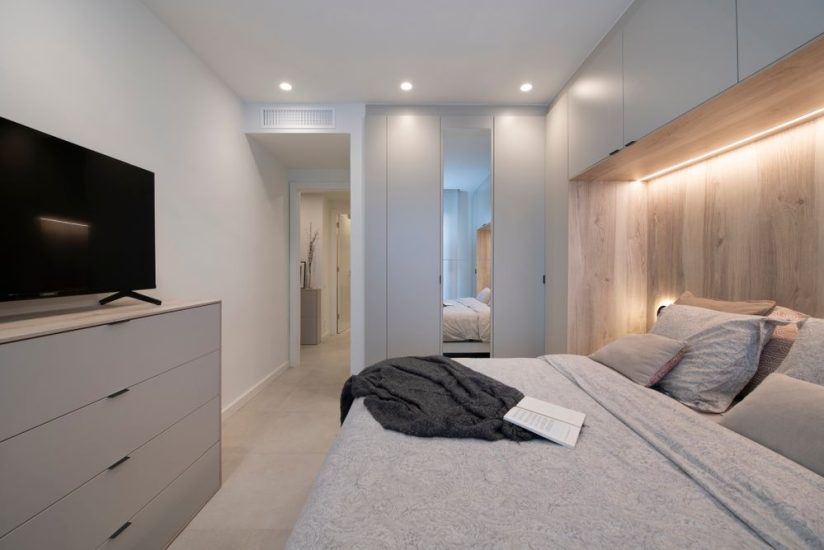 Dormitorio principal con mucho espacio de almacenamiento gracias a los muebles fabricados a medida