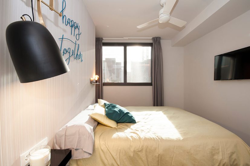 Dormitorio principal moderno con tonos grises.