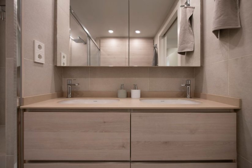 Lavabo con dos aseos integrados en el mueble de madera.