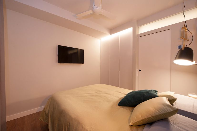 Televisión colgada a la pared en dormitorio principal