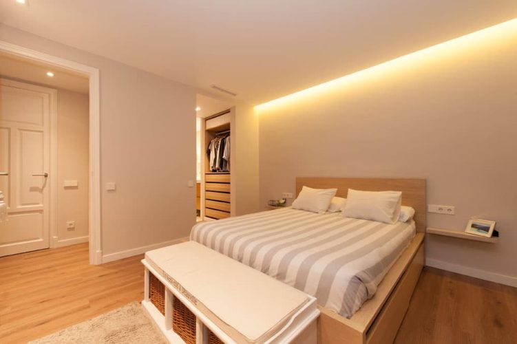 Dormitorio con cama y banquillo de pie cama. Piso ubicado en Barcelona.