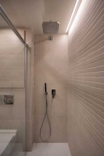 Ducha con tira led y ladrillo con textura en color beige