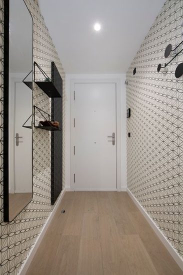 Recibidor con diferentes papeles pintados en beige y negro y figuras geométricas.