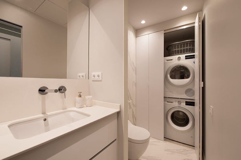 Lavandería en el cuarto de baño oculto por en un armario con puertas correderas.