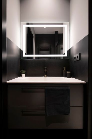 Moble suspès negre amb dos calaixos amb lavabo blanc integrat i mirall amb llum