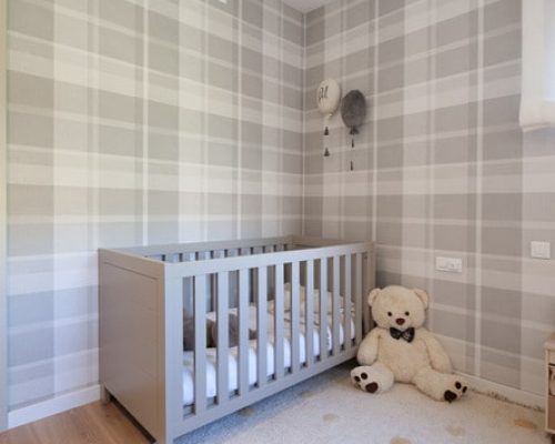 Dormitorio infantil con papel pintado clásico con cuadros estilo inglés escocés en gris.