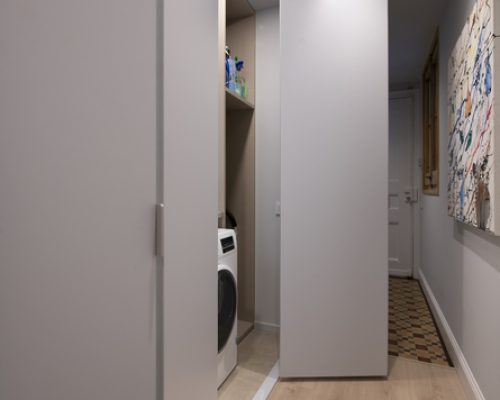 Armario pasillo con puertas plegables con la zona de lavado dentro con lavadora y secadora.